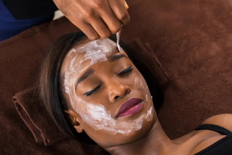 African woman receiving a facial at a spa